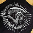 Black t-shirt with a white alien design on a wooden surface
