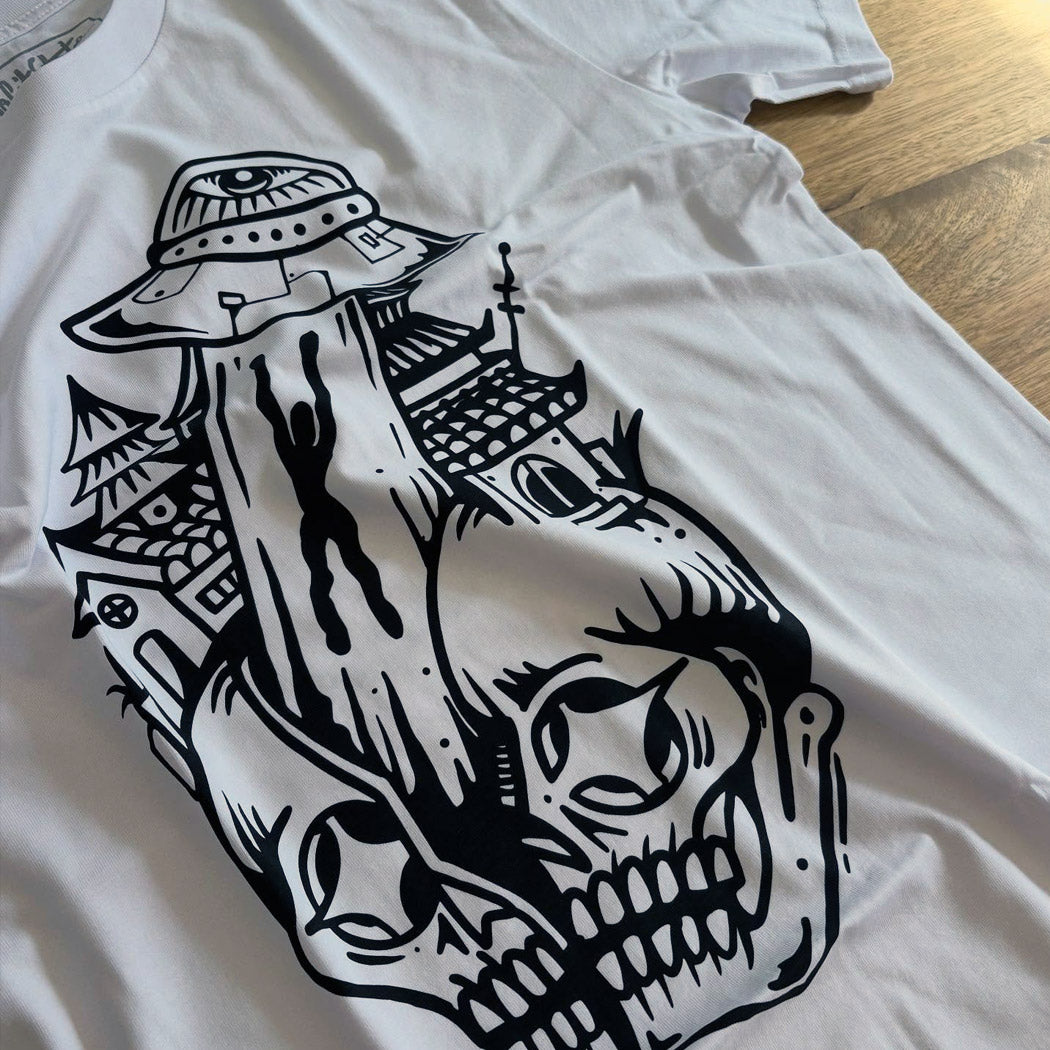 White t-shirt with black graphic design on a wooden surface