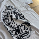 White t-shirt with black graphic design on a wooden surface